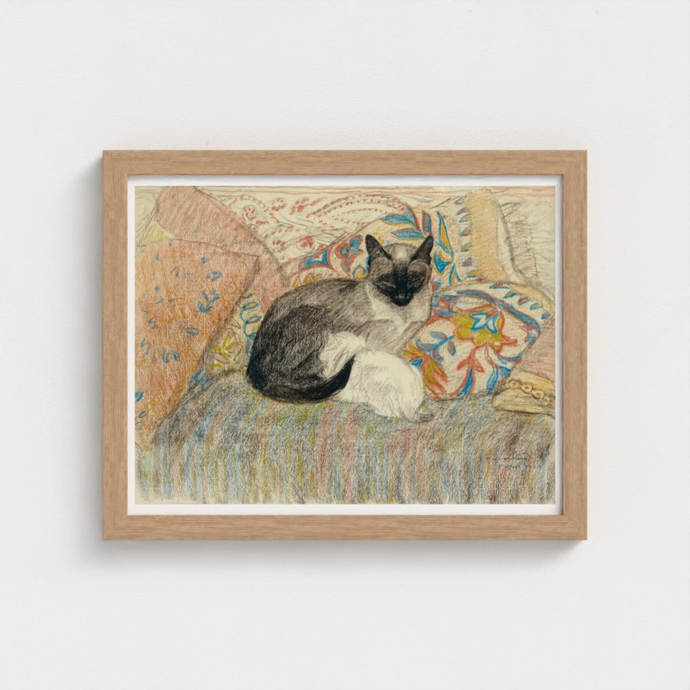 Framed artwork of a cat sitting on a patterned chair.