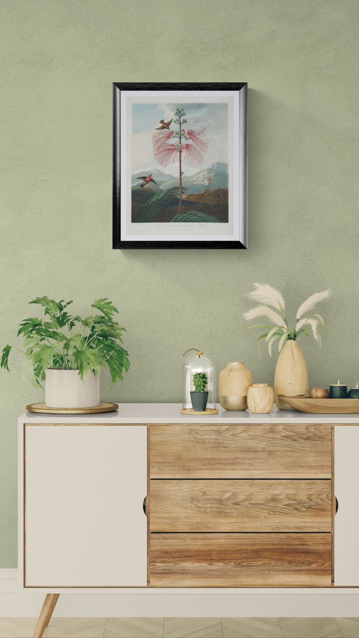 Wooden sideboard with decorative items against a green wall with a framed artwork.
