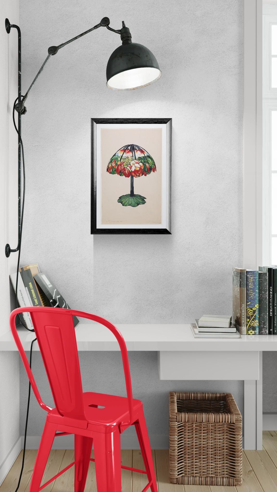 Red chair in front of a desk with a framed artwork on the wall.
