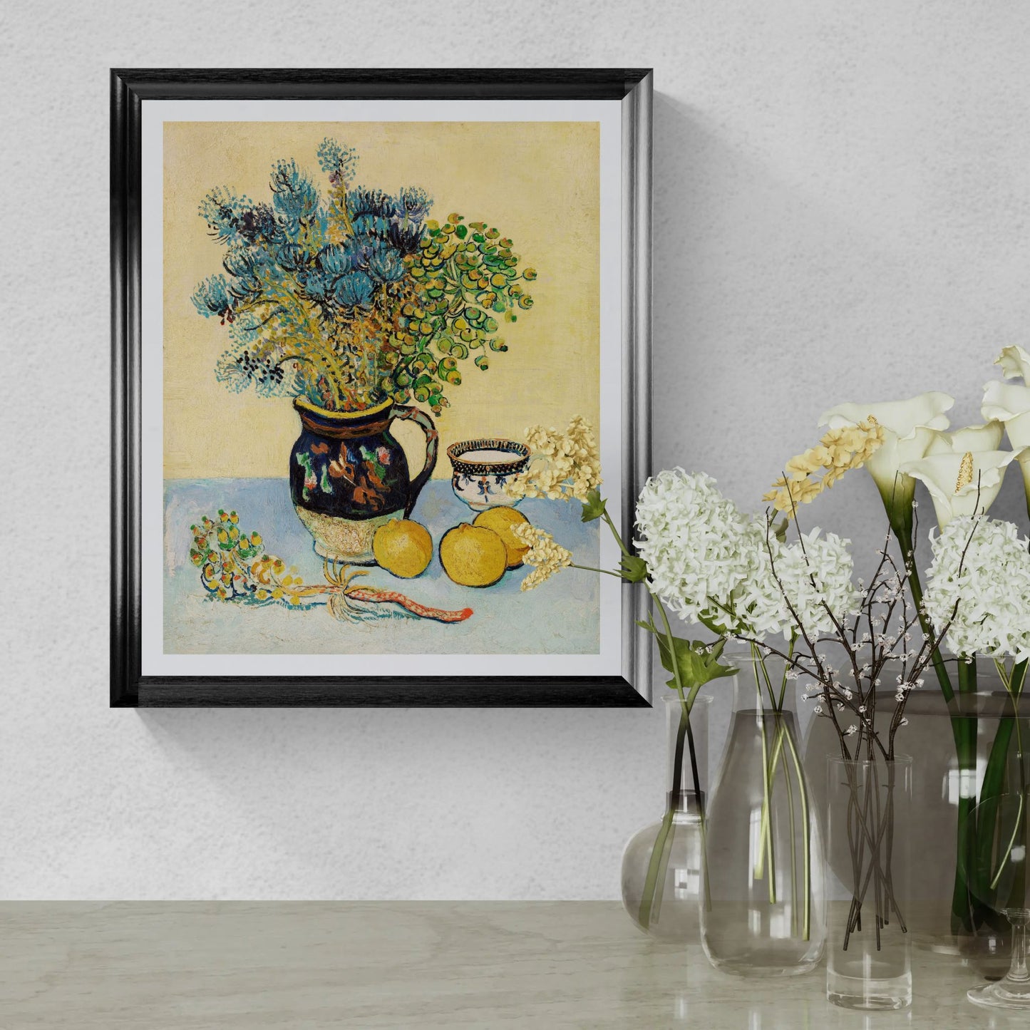Framed still life painting with flowers and fruit on a wall next to real vases with flowers.
