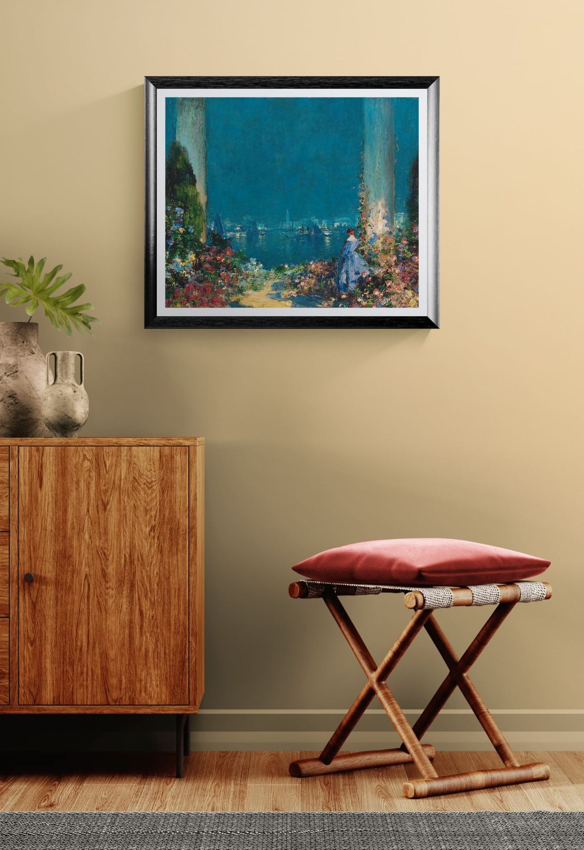 Framed painting on a wall above a wooden cabinet and stool with a red cushion.