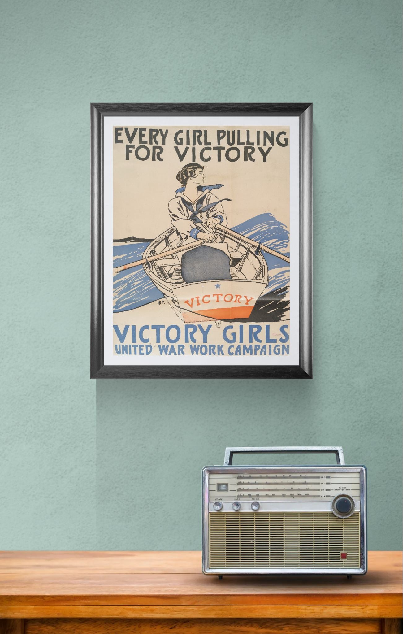Framed vintage poster on a wall with a radio below