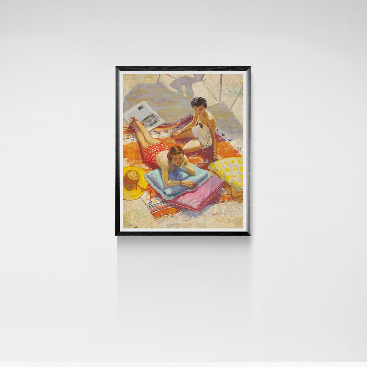 Framed artwork of a beach scene with two women on towels.