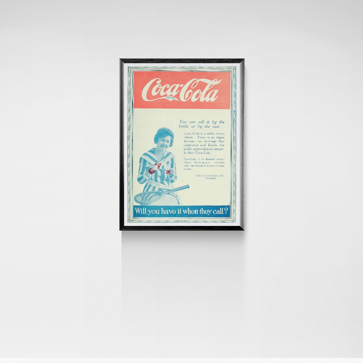 Framed Coca-Cola advertisement on a white wall