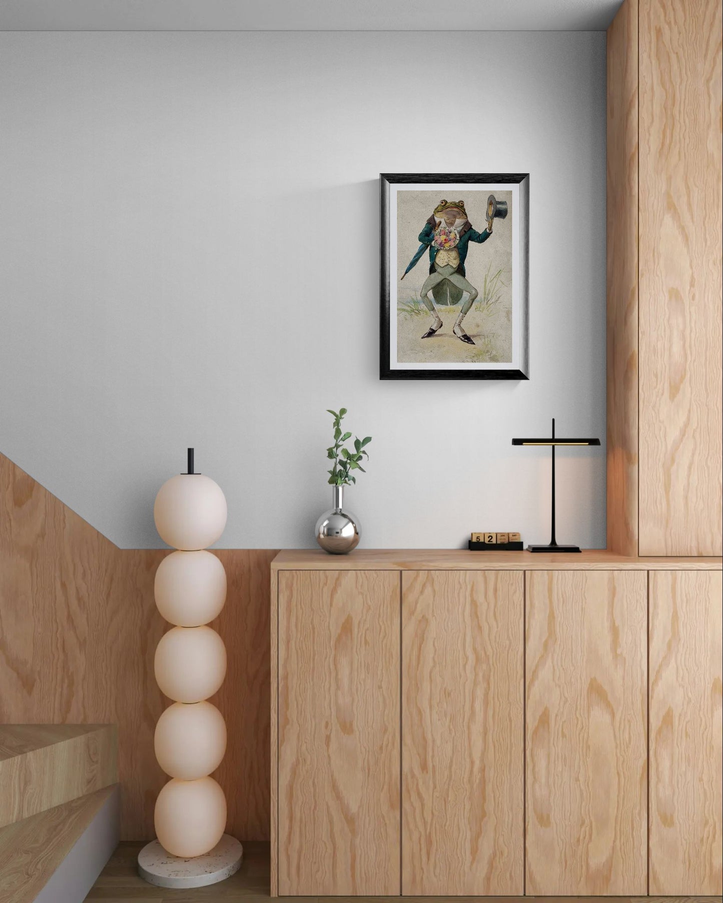 Modern interior with wooden cabinet, decorative lamp, and framed artwork on a light gray wall.