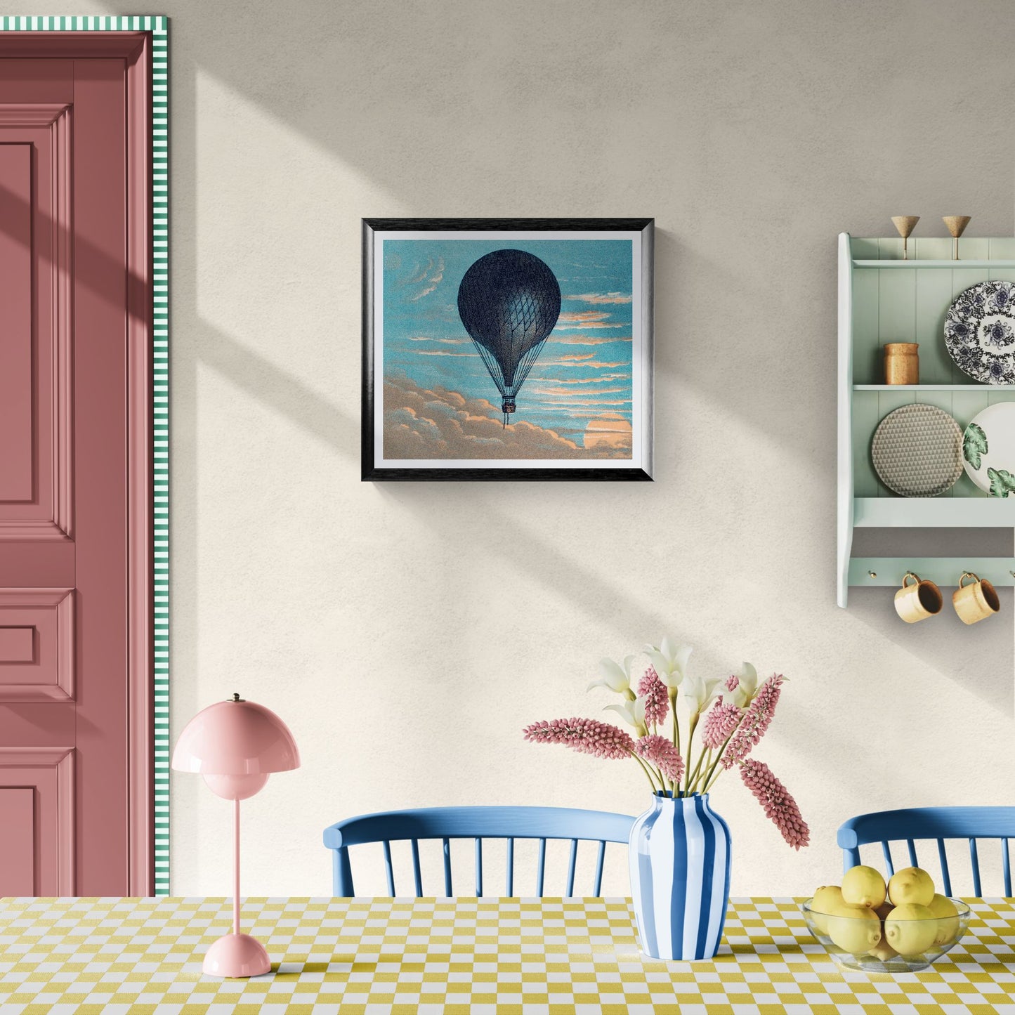 Dining room with a pink lamp, blue chairs, and a framed hot air balloon print on the wall.