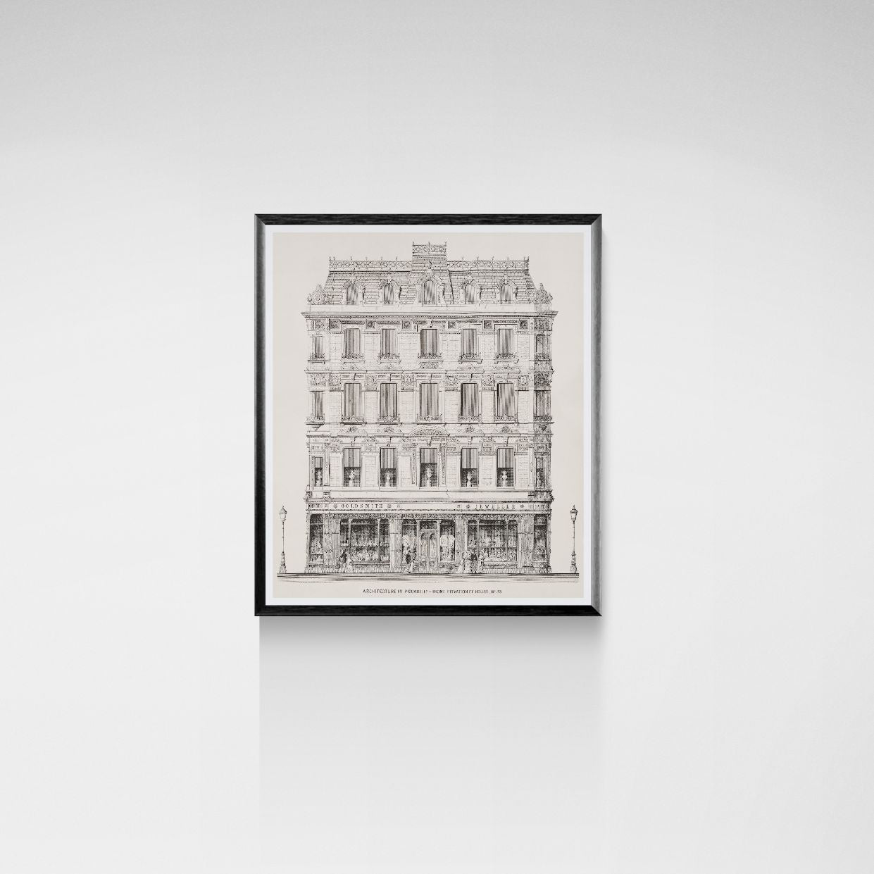 Framed black and white architectural drawing of a building on a white wall