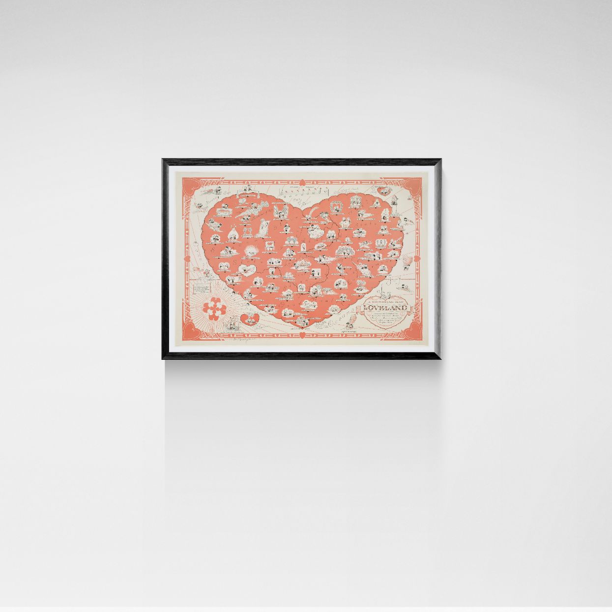 Framed artwork with a heart-shaped design on a white wall
