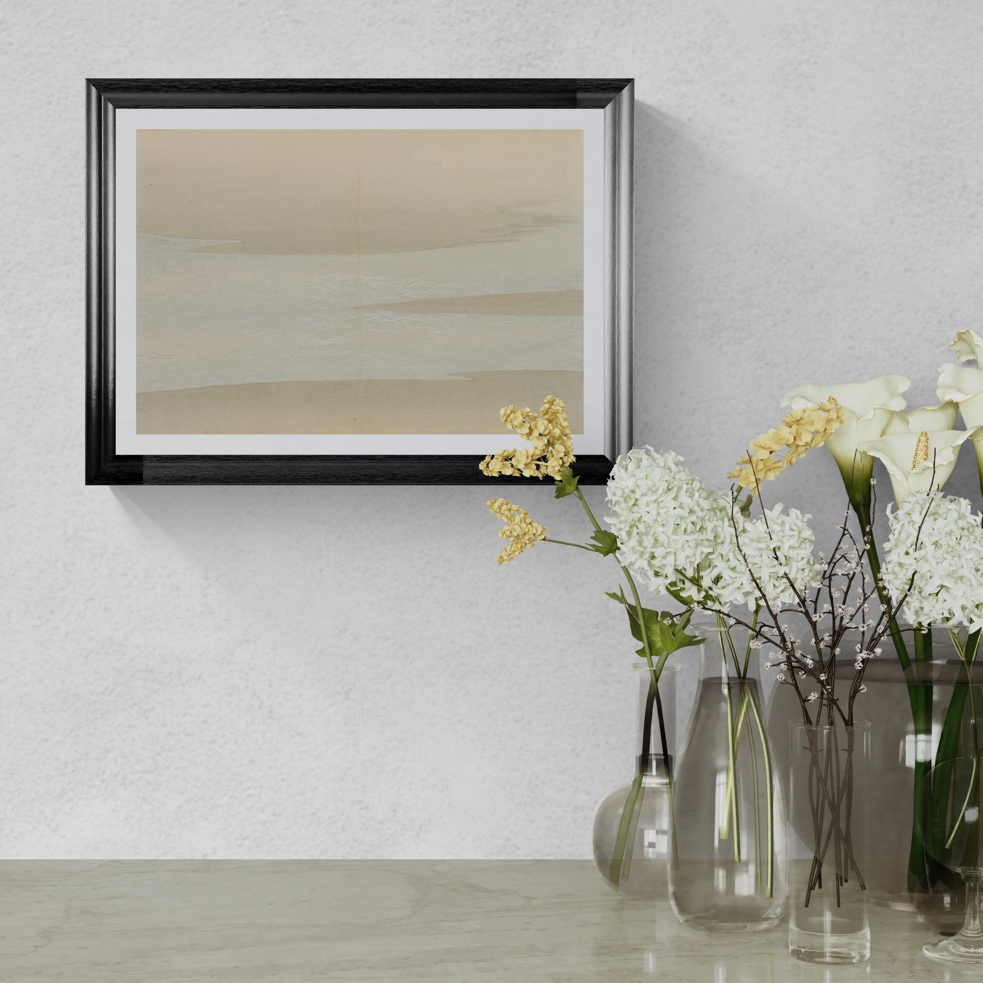 Framed abstract art on a wall with vases of flowers below