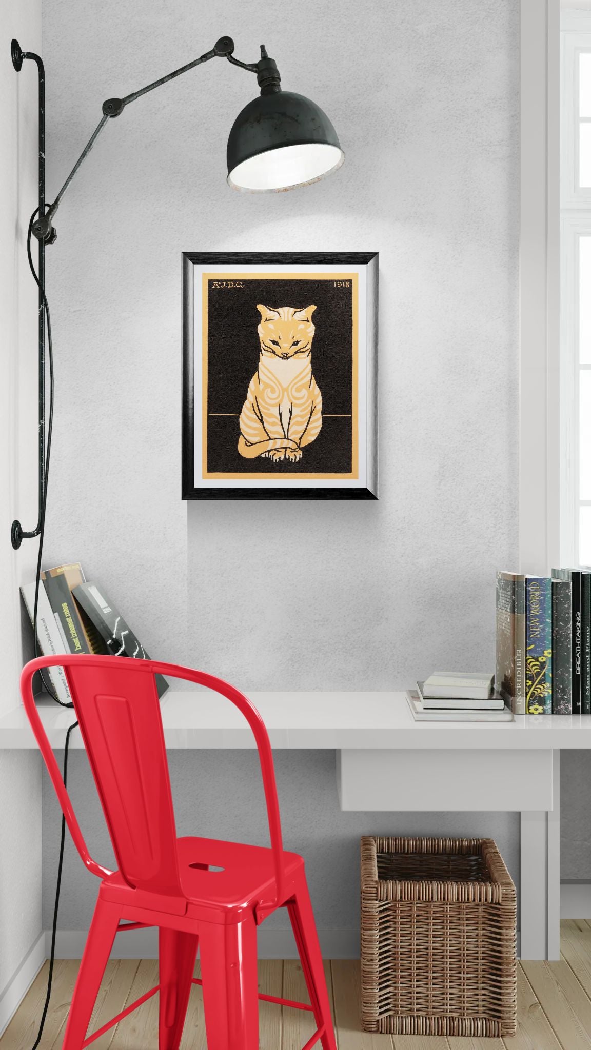 Modern interior with a red chair, white desk, and framed cat artwork on a gray wall.