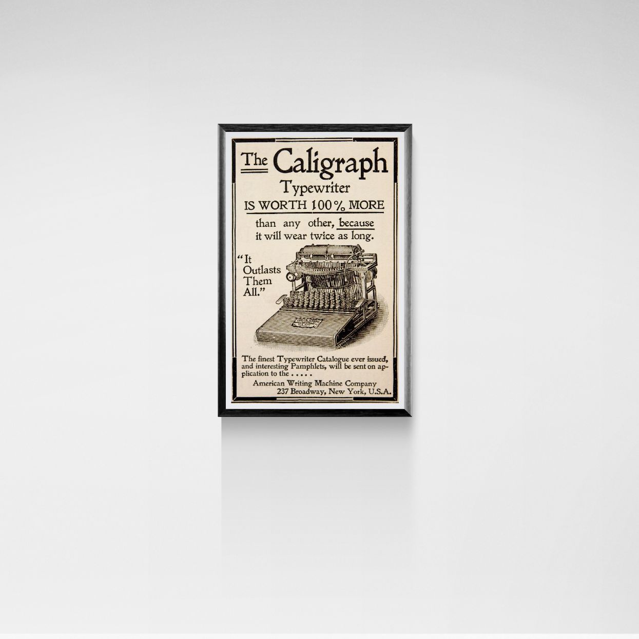 Framed advertisement for The Caligraph Typewriter on a white wall