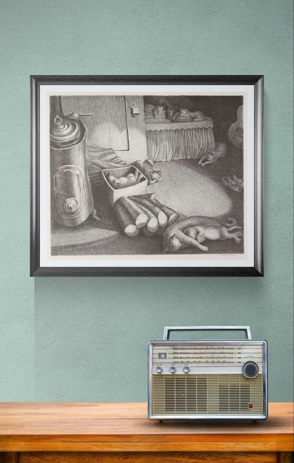 Framed black and white artwork on a teal wall with a vintage radio below.