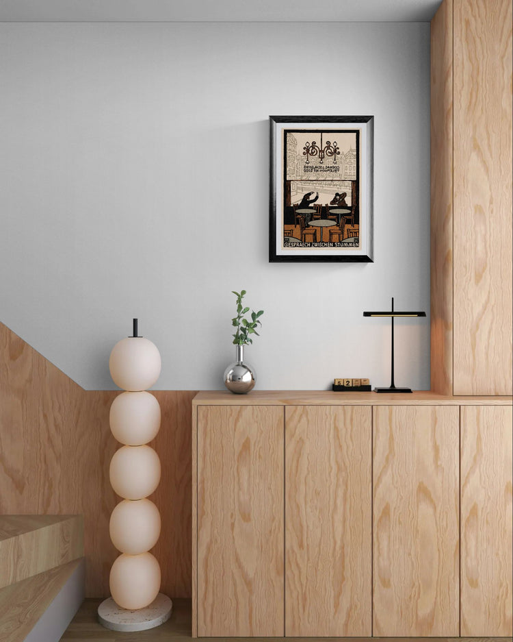 Modern interior with wooden cabinet, decorative lamp, and framed artwork on a light gray wall.