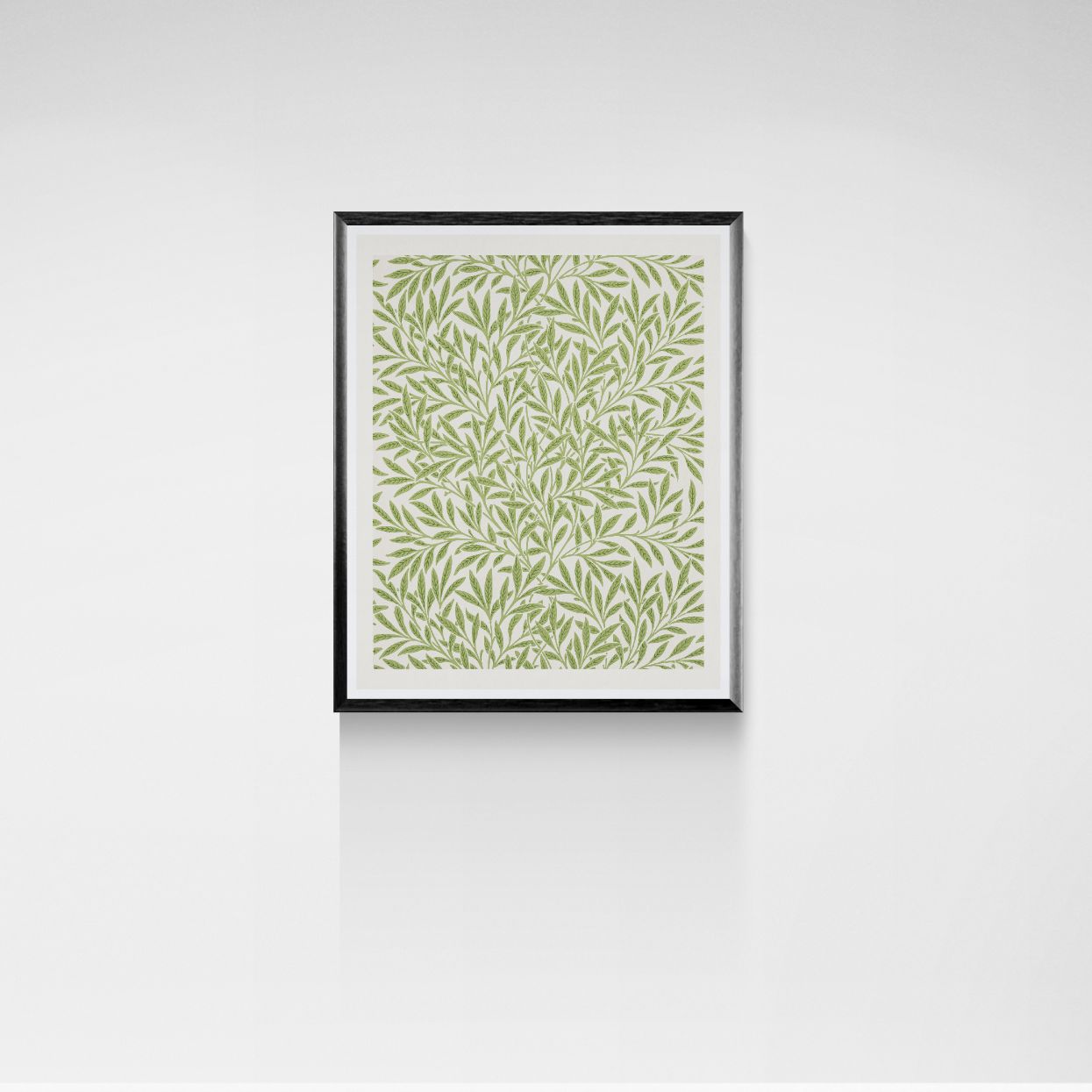 Framed artwork with a green leaf pattern on a white wall